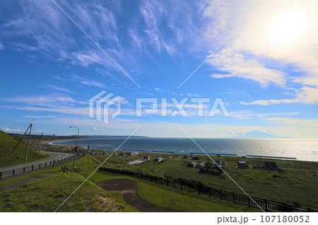 日本最大の高層湿原、北海道の利尻礼文サロベツ国立公園、サロベツの原野で洋上の利尻島を眺める、その夕日 日本最大の高層湿原、北海道の利尻礼文サロベツ国立公園、サロベツの原野で洋上の利尻島を眺める、その夕日 107180052