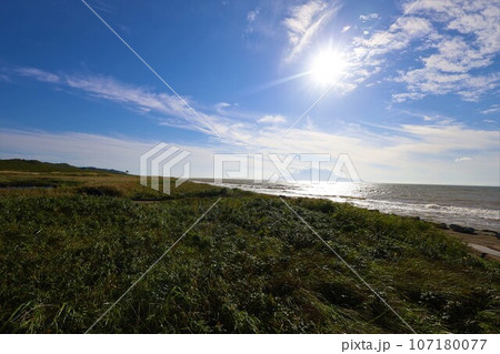 日本最大の高層湿原、北海道の利尻礼文サロベツ国立公園、サロベツの原野で洋上の利尻島を眺める、その夕日 日本最大の高層湿原、北海道の利尻礼文サロベツ国立公園、サロベツの原野で洋上の利尻島を眺める、その夕日 107180077