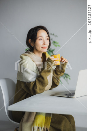 コーヒーを飲みながらパソコンを見る女性 107182127