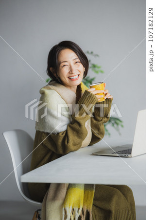 コーヒーを飲みながらパソコンを見る女性 107182129