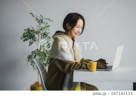 コーヒーを飲みながらパソコンを見る女性 107182133