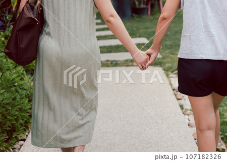 LGBTQ couple walking with hand holding hands. LGBTQ couple walking with hand holding hands. 107182326