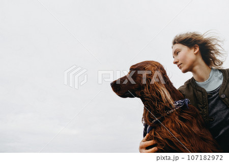 Portrait of a young woman with her dog. 107182972