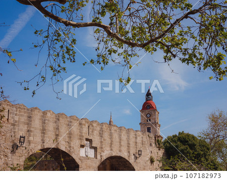 Medieval Roloi Clock Tower over blue sky in sunny day, Old Town of Rhodes, Rhodes, Greece, travel to famous place 107182973