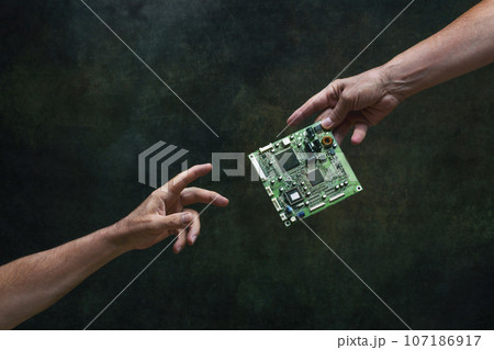 A man's hand passes a computer board to another person. Data transmission 107186917