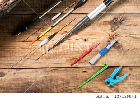 Tools and items for the fisherman. Tools on a wooden table. Warm light. View from above. Tools and items for the fisherman. Tools on a wooden table. Warm light. View from above. 107186941