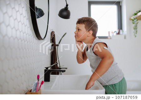 The diabetic boy getting ready in the morning, while wearing a continuous glucose monitoring sensor on his arm. 107187059