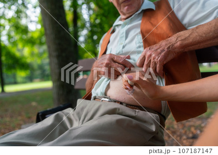 Nurse injecting insulin in belly of diabetic senior patient. 107187147