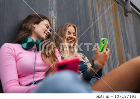 Young stylish generation Z girls spending time together outdoors after school. 107187193
