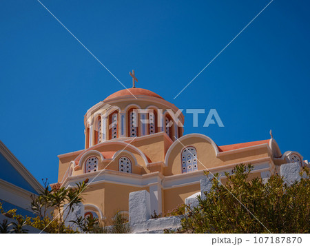 Symi Island, Greece. Greece islands holidays from Rhodos in Aegean Sea. Colorful neoclassical Church of the Annunciation is Greek Orthodox Church Symi Island, Greece. Greece islands holidays from Rhodos in Aegean Sea. Colorful neoclassical Church of the Annunciation is Greek Orthodox Church 107187870