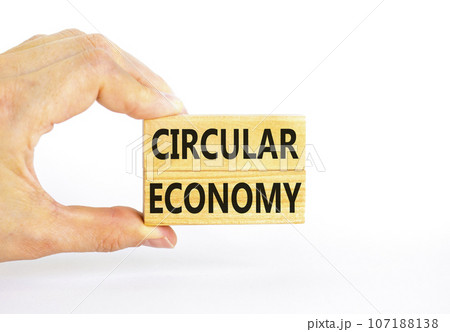 Circular economy symbol. Concept words Circular economy on beautiful wooden block. Beautiful white table white background. Businessman hand. Business circular economy concept. Copy space. 107188138