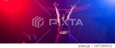 Banner little girl holds broom on Halloween holiday copy space. Kid girl wear witch costume. Fantasy, fairy tale and masquerade concept. 107189521