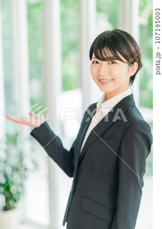 爽やかな明るい部屋でポーズをとるスーツ姿の若い女性 107195003