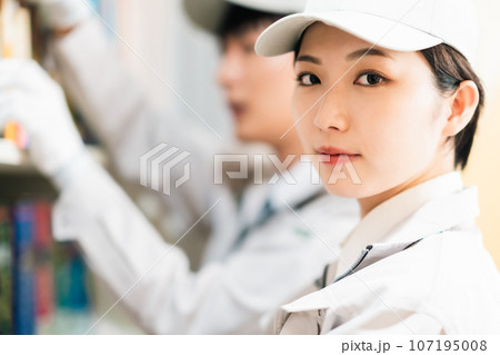 部屋の整理をする真面目な女性スタッフ 107195008