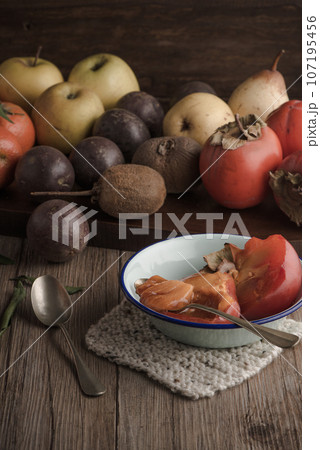 Persimmon fruit on rustic table 107195456