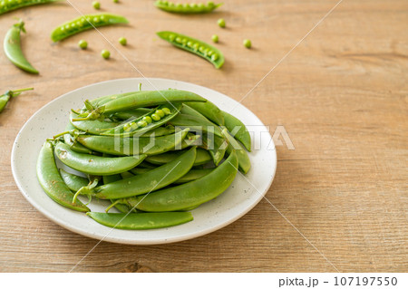 fresh sweet green peas on plate fresh sweet green peas on plate 107197550