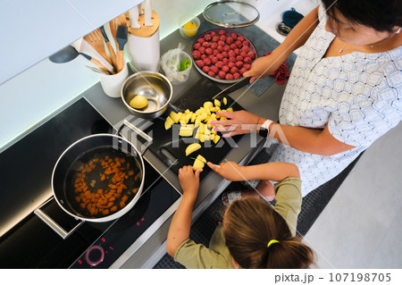 Grandmother and granddaughter are preparing soup. Grandmother and granddaughter are preparing soup. 107198705