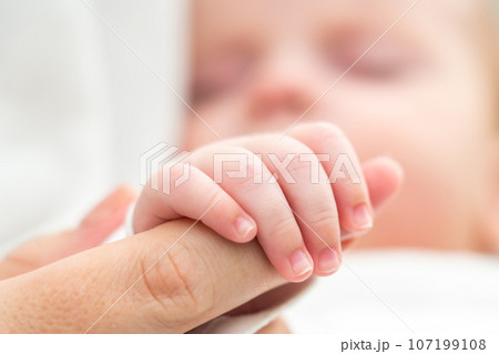 Mother's finger becomes an anchor of love. Concept of the foundational trust in newborn's world 107199108