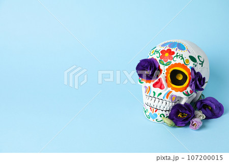 Mexican skull and flowers on blue background, space for text Mexican skull and flowers on blue background, space for text 107200015
