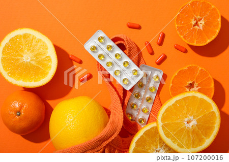 Vitamin C, in tablets, plates with oranges, on the table. Vitamin C, in tablets, plates with oranges, on the table. 107200016
