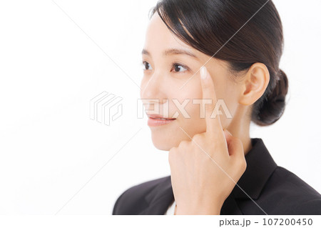 目元を指差すスーツ女性の写真 107200450