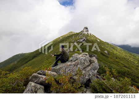 金峰山の五丈岩を背景に一休みする男性 金峰山の五丈岩を背景に一休みする男性 107201113