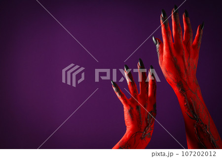 Creepy, red hands of a monster with black nails 107202012
