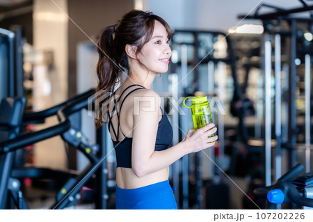 スポーツジムでトレーニングする若い女性 107202226