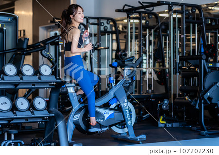 スポーツジムでトレーニングする若い女性 107202230