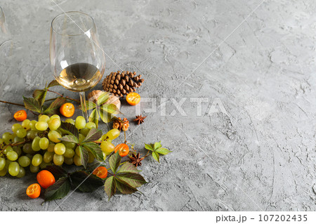 Grapes and glass of wine on gray background, space for text Grapes and glass of wine on gray background, space for text 107202435