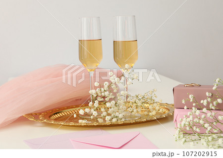 Gift boxes, flowers and glasses with wine on light background Gift boxes, flowers and glasses with wine on light background 107202915