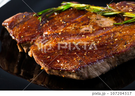 Grilled beef steak with rosemary 107204317