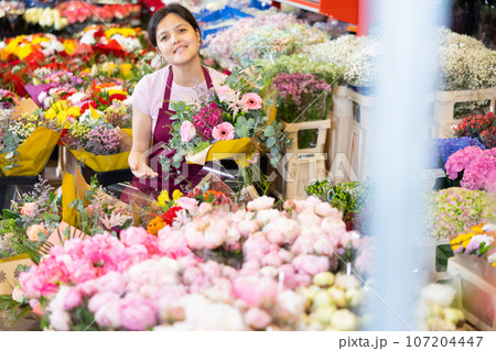Portrait of female flower market seller with bouquets of flowers 107204447