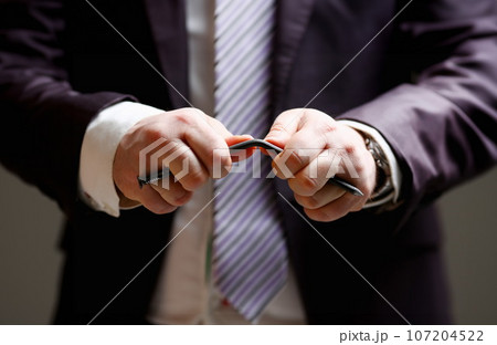 Man in suit and tie bend nail with arms closeup 107204522