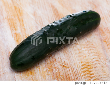 Many ripe cucumbers on wooden surface 107204612