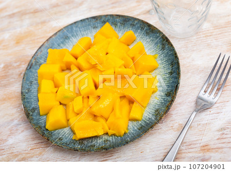 On round plate with blue border - pieces of cubed ripe peeled mango On round plate with blue border - pieces of cubed ripe peeled mango 107204901