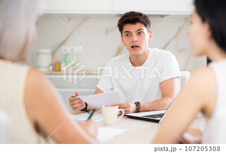 Male realtor is discussing the terms of real estate sale with an elderly woman and her adult daughter Male realtor is discussing the terms of real estate sale with an elderly woman and her adult daughter 107205308