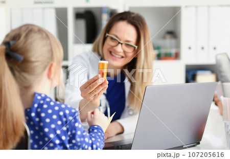 Beautiful smiling female doctor hold in arms pill Beautiful smiling female doctor hold in arms pill 107205616