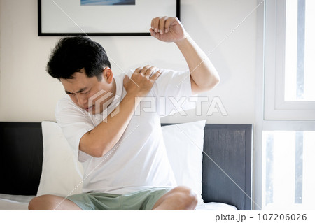 Asian middle aged man suffering from frozen shoulder,pain and stiffness,unable to move,difficulty lifting his arm,male people with calcific tendonitis or shoulder injuries,health care,medical concept 107206026