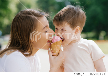 Young mom and son enjoying their summer holidays and eating ice cream Young mom and son enjoying their summer holidays and eating ice cream 107206174