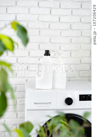 Detergent bottle on washing machine in a laundry room 107206429