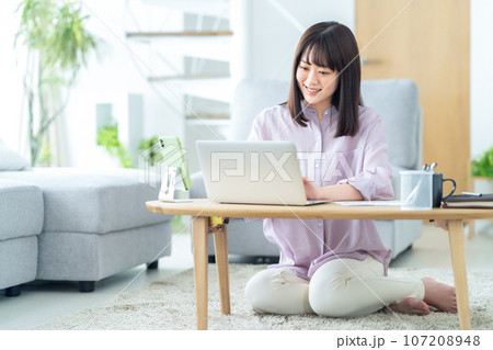 リビングでテレワークをする若い女性 リビングでテレワークをする若い女性 107208948