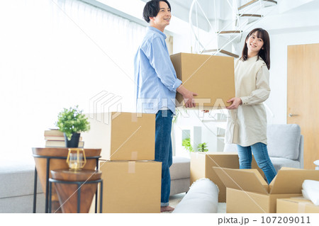 引っ越しの荷造りをする若いカップル 107209011