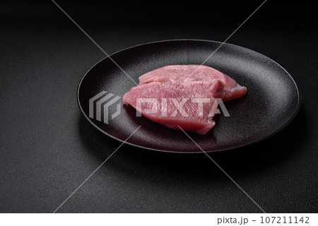 Raw turkey meat in the form of slices with salt, spices and herbs Raw turkey meat in the form of slices with salt, spices and herbs 107211142