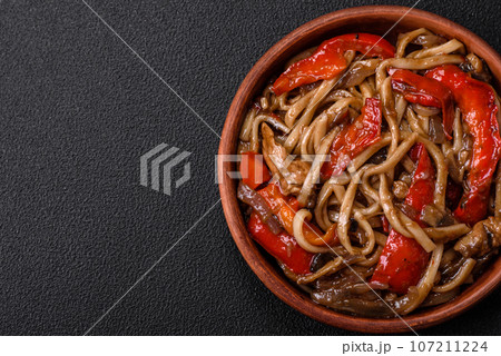 Delicious asian udon dish with vegetables, mushrooms, salt and spices Delicious asian udon dish with vegetables, mushrooms, salt and spices 107211224