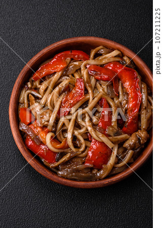Delicious asian udon dish with vegetables, mushrooms, salt and spices Delicious asian udon dish with vegetables, mushrooms, salt and spices 107211225