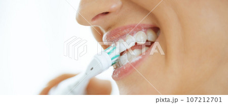 Closeup on young woman brushing teeth Closeup on young woman brushing teeth 107212701