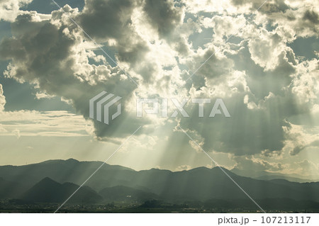 太陽に照らされて黄金色に輝く空（薄明光線） 107213117