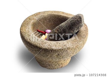 Side view of rock morta with red chilli, onion, garlic and pestle isolated on white background. 107214308