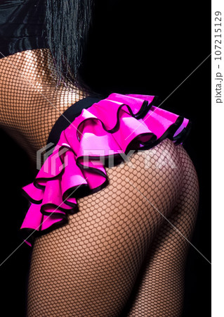 Female sexy figure legs in mesh tights and pink skirt and beautiful butt on black background Female sexy figure legs in mesh tights and pink skirt and beautiful butt on black background 107215129